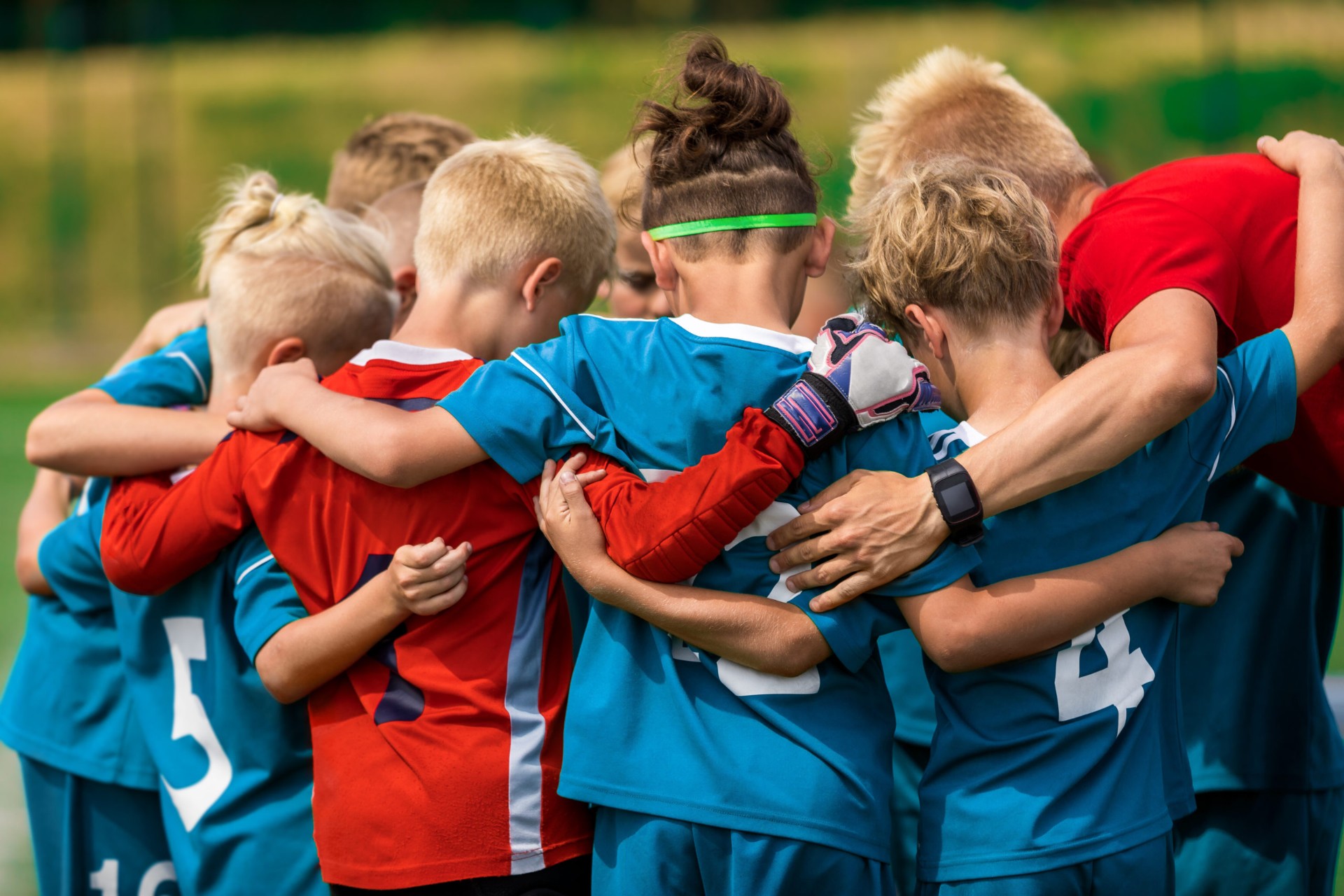 Youth athletes huddled together on a sports field